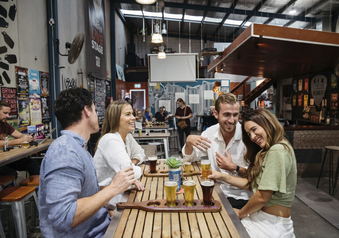 セントラル・コーストのエリナにあるシックス・ストリング・ブリューイング・カンパニーの醸造所でビールの試飲を楽しむ友人たち