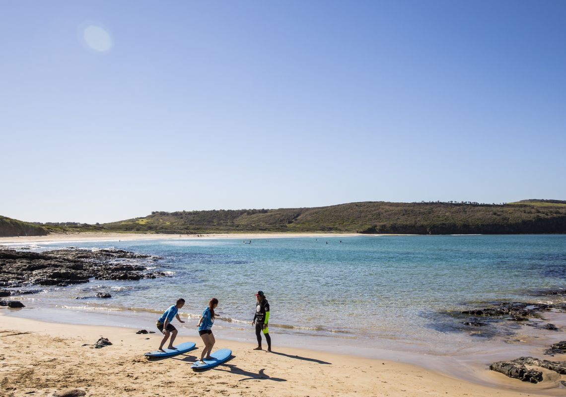Couple learning to surf with Pines Surfing Academy Surf School at Killalea Beach ('The Farm'), Shell Cove