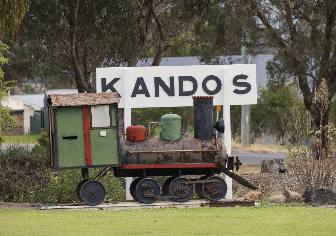 Mini steam train sits alongside a Kandos train station sign in Kandos , Mudgee