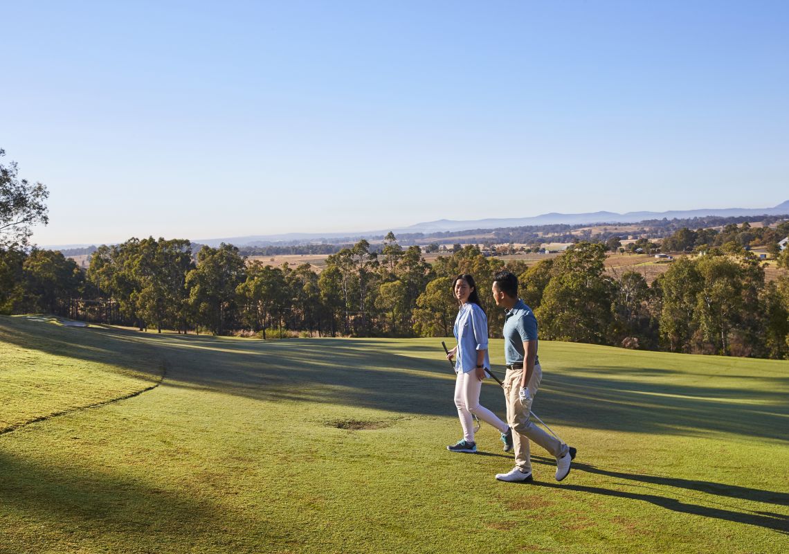 A couple enjoying a day on the golf course at Oaks Cypress Lakes Resort in Pokolbin, Hunter Valley