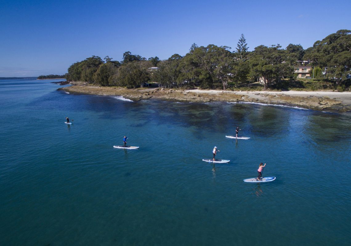 Group of friends enjoying a day on the water paddleboarding at Orion Beach, Vincentia, Jervis Bay & Shoalhaven
