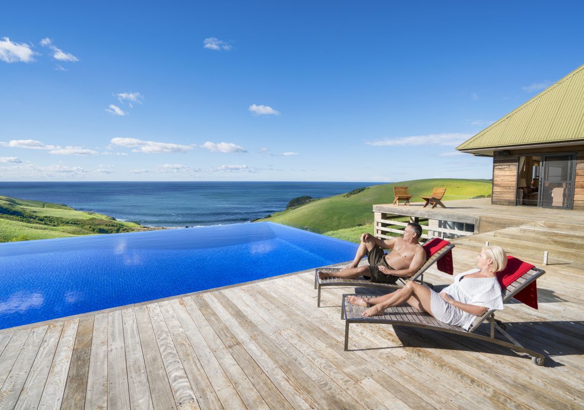 Couple relaxing by the pool at Ocean Farm luxury accommodation in Gerringong, Kiama Area, South Coast