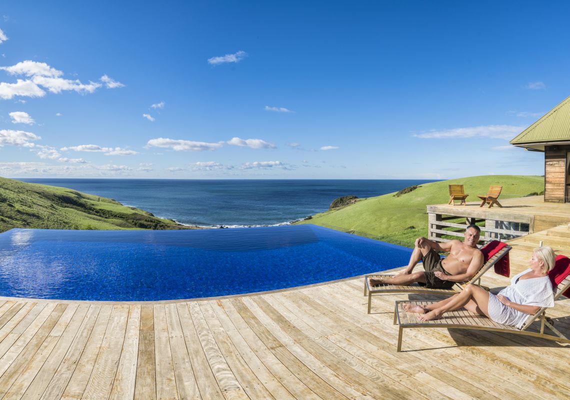 Couple relaxing by the pool at Ocean Farm luxury accommodation in Gerringong, Kiama Area, South Coast