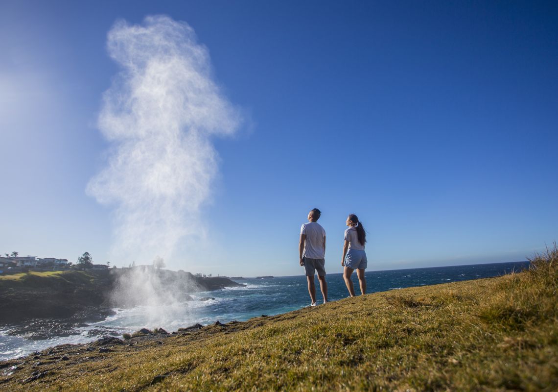 Couple watching the water plume from the Kiama blowhole in Kiama, South Coast