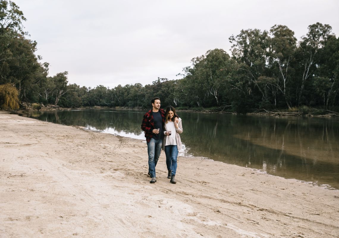Couple enjoying a walk along the banks of the Murray River at Ulupna Island in Tocumwal, The Murray, Country NSW