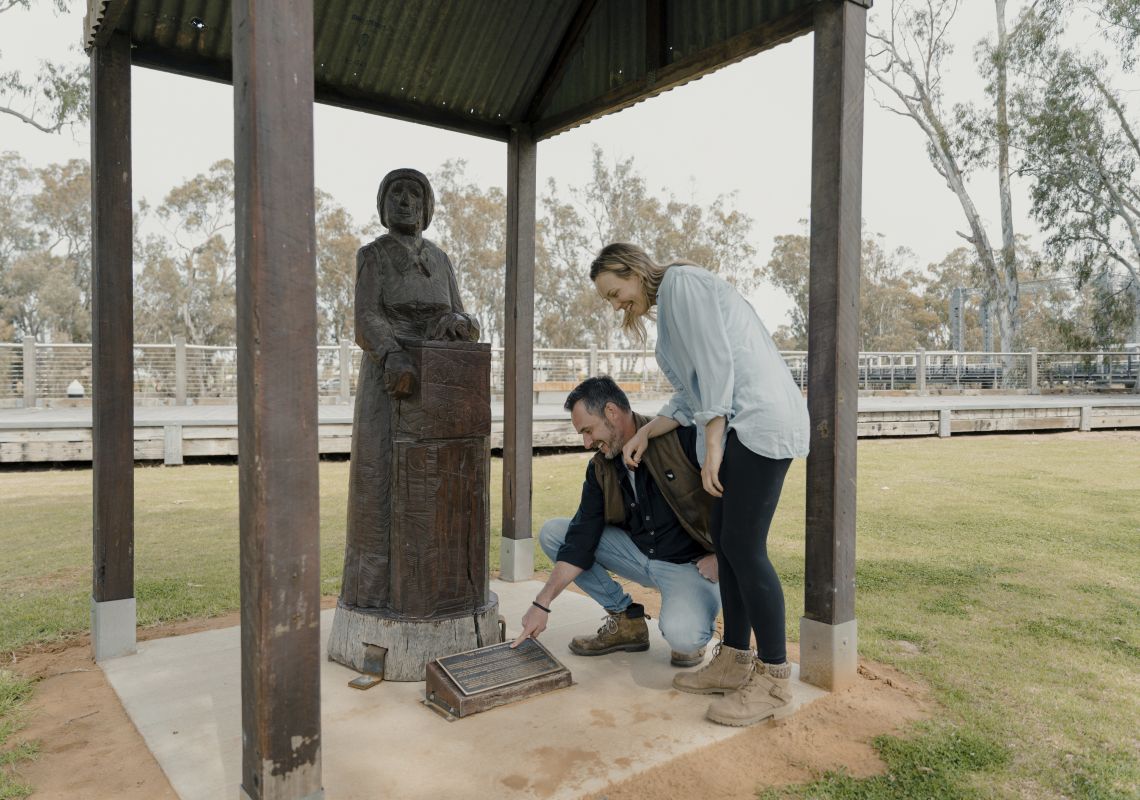 Couple viewing The Pioneed Woman statue along the Koondrook Barham Redgum Statue River Walk in Barham.
