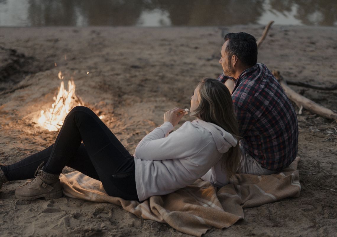 Couple enjoying a campfire by Murray River, Moama, The Murray