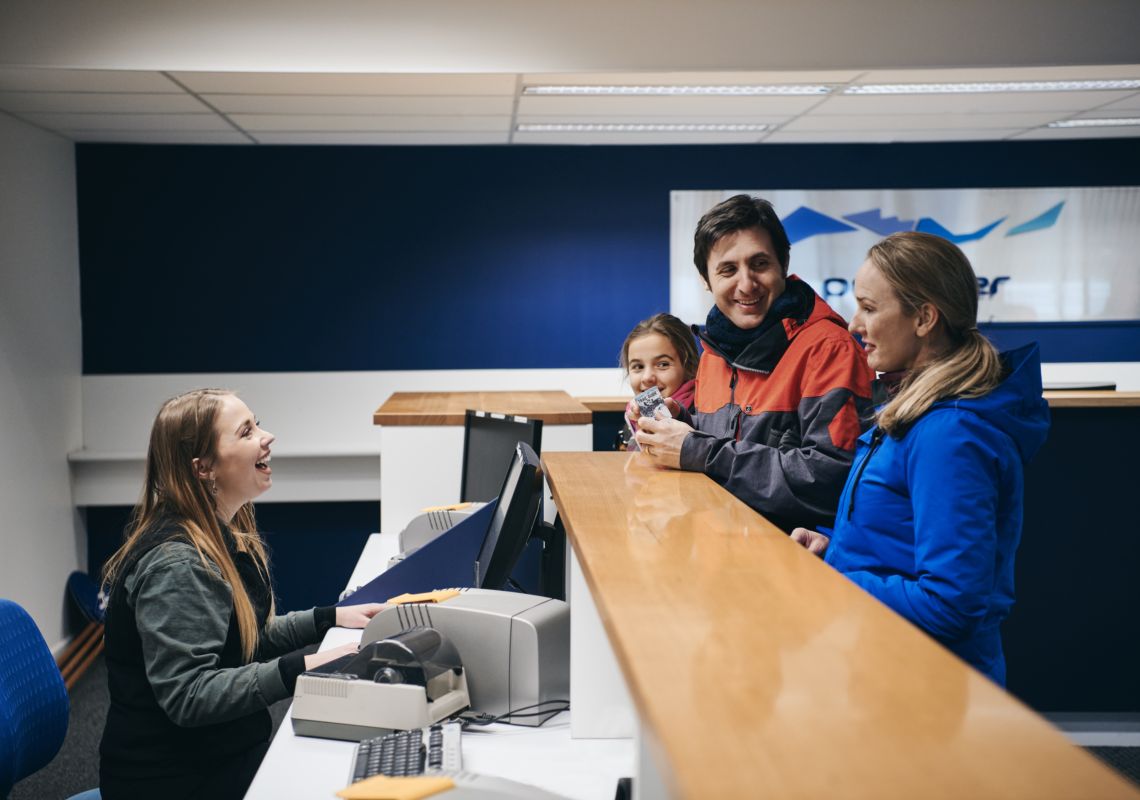 Family purchasing their ski passes at the Perisher ticket office in Perisher, Snowy Mountains
