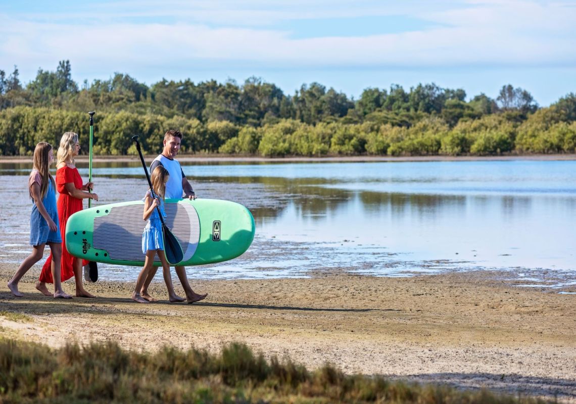 Family doing Paddle boarding in Discovery Parks at Harrington Beach, Forster & Taree, North Coast