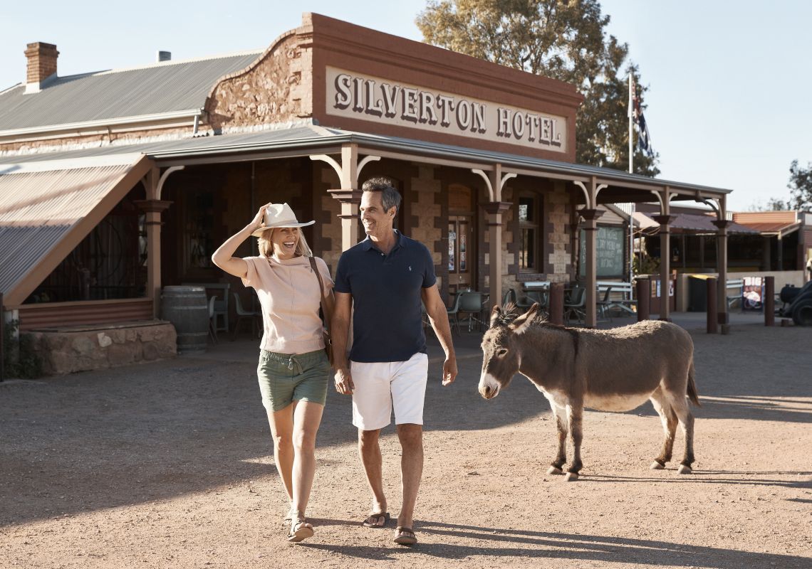 Couple with a local donkey outside the Silverton Hotel at Silverton in Broken Hill, Outback