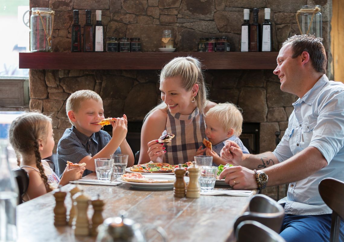 family enjoying the pizza at Alpine Larder Cafe in Crackenback, Jindabyne, Snowy Mountains