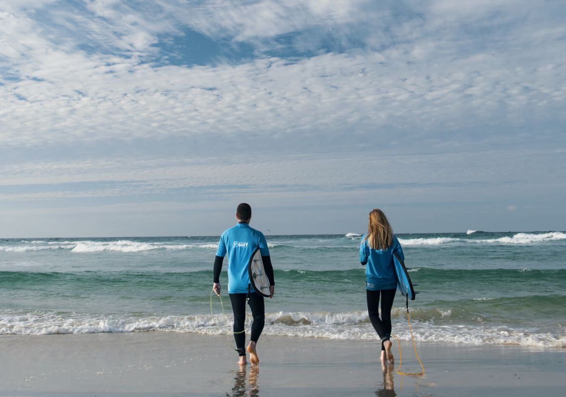 Couple enjoying a surfing lesson with In 2 Surf Surf School, Kingscliff