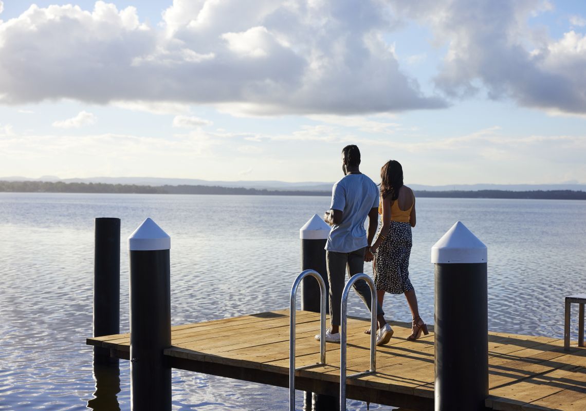 Couple enjoying the sunshine and lviews across Budgewoi Lake from Beachcomber Hotel and Resort, Toukley
