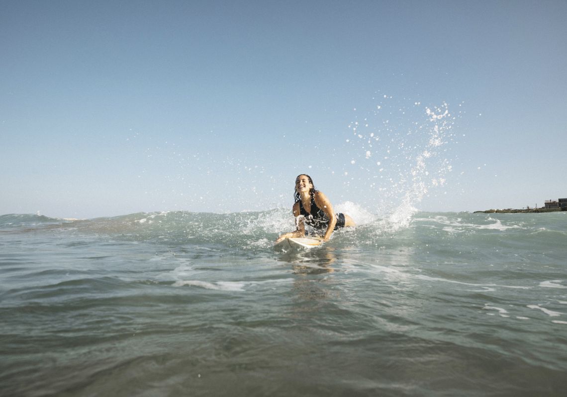 Woman enjoying a morning surf at Birubi Beach, Port Stephens