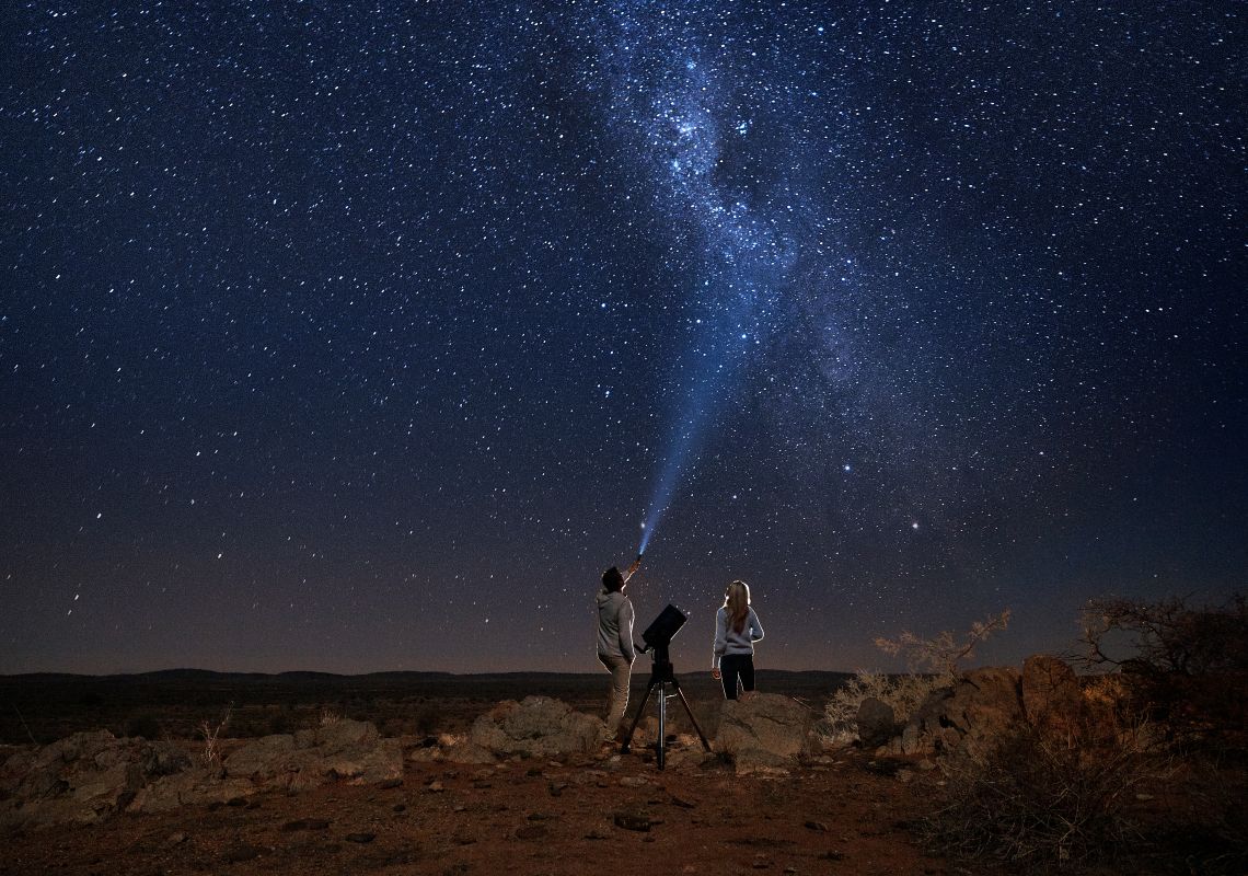 Couple star gazing beneath the Milky Way at Outback Astronomy