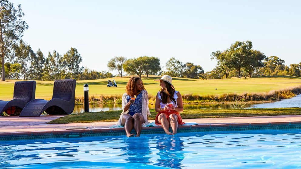 Friends relaxing by the pool at Oaks Cypress Lakes Resort in Pokolbin, Hunter Valley
