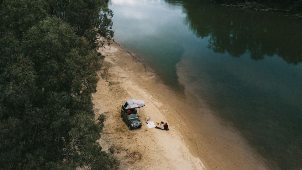 Couple enjoying a camping weekend away on the banks of the Murray River at Ulupna Island in Tocumwal, The Murray, Country NSW