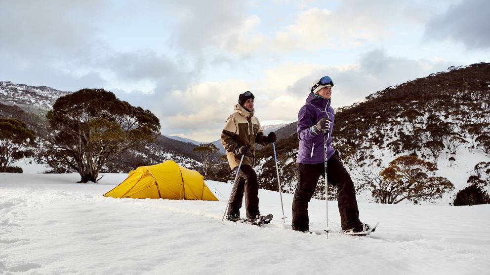 Couple snowshoeing by their campsite through Dead Horse Gap, Thredbo in the Snowy Mountains