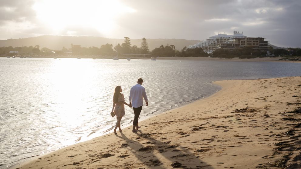Couple enjoying a walk along Ettalong Beach at sunset, Gosford Area