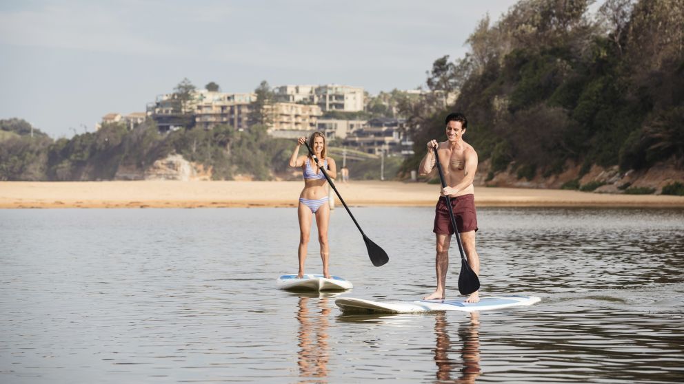 Couple enjoying a day of stand up paddleboarding on Terrigal Lagoon, Terrigal in Gosford Area