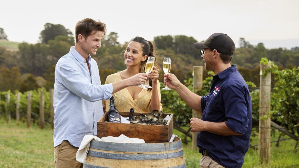 Couple enjoying Swift Sparkling Wine and oysters with scenic views across Printhie Wines vineyard in Nashdale, near Orange