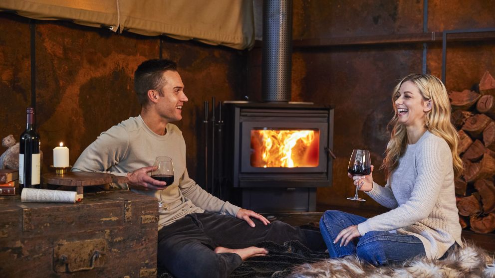 Couple enjoying a romantic night by the fireplace at Spicers Sangoma Retreat, Bowen Mountain