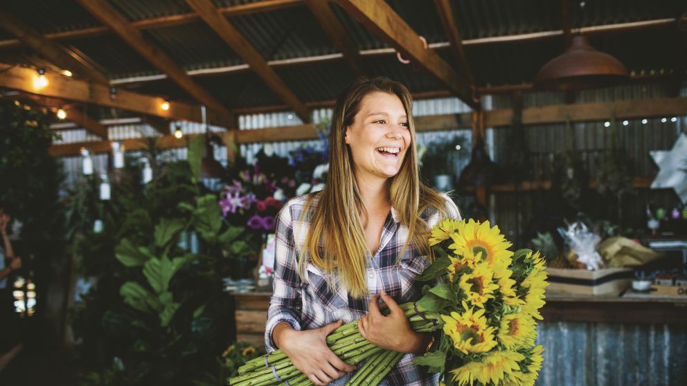 Woman with a bunch of sunflowers at The Farm, Byron Bay
