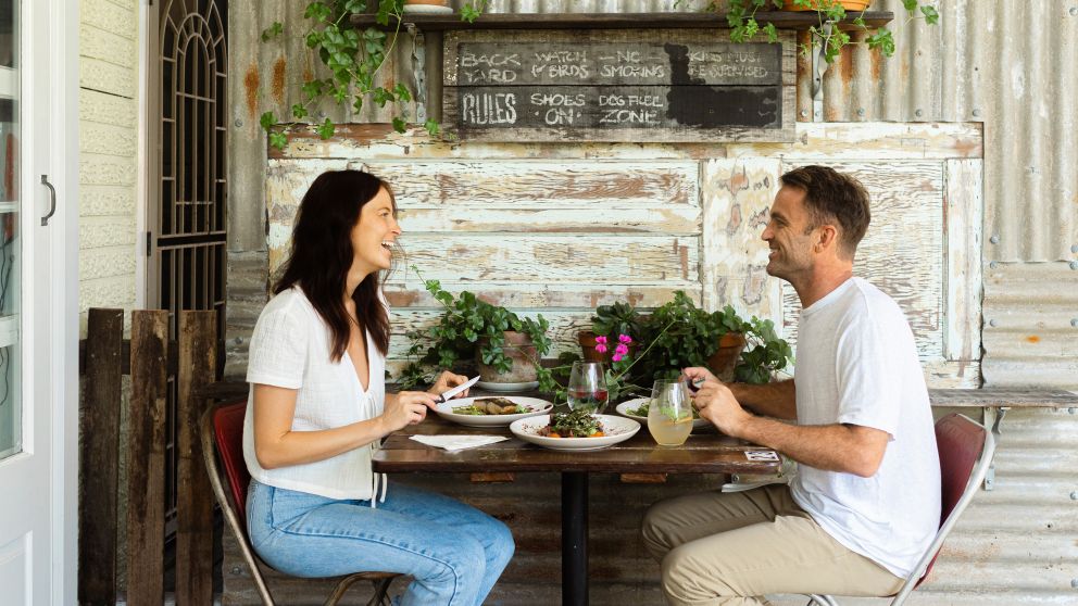 Couple enjoying food and drink at Yum Yum Angourie Cafe and General Store, Yamba