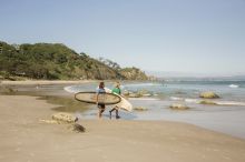 Two surfers holding their longboards survey Wategos Beach, Byron Bay