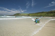 Children heading out for a surf at Killalea State Park