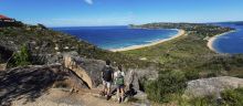 Couple enjoying a scenic coastal hike on the Barrenjoey Lighthouse Walk in Palm Beach, Sydney