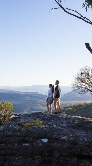  Couple enjoying panoramic views across to Pigeon House Mountain (Aboriginal: Didthul) in Morton National Park, Jervis Bay and Shoalhaven Area