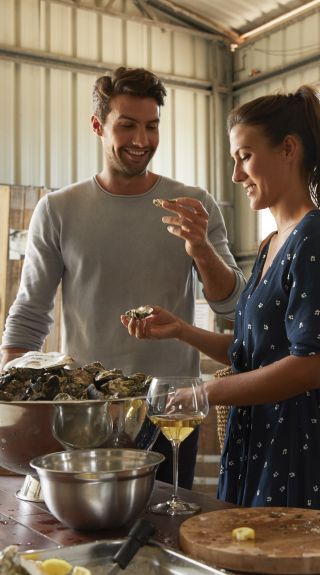 Couple enjoying freshly opened oysters with Jim Wild of Jim Wild's Oysters, Greenwell Point