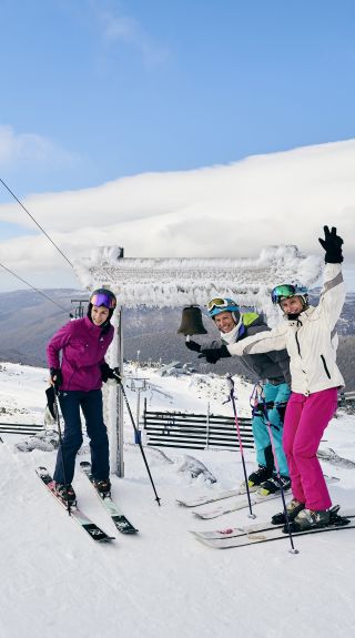 Skiers ringing the Thredbo Community Bell at Australia's Highest Lifted Point, Thredbo in the snowy Mountains