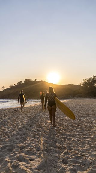 Women heading out for a morning surf at Cabarita Beach