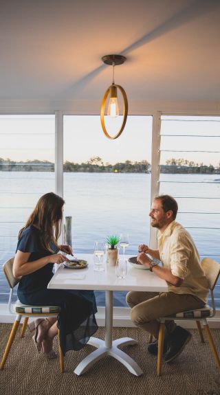 Couple enjoying food and drink at Whalebone Wharf in Port Macquarie, North Coast