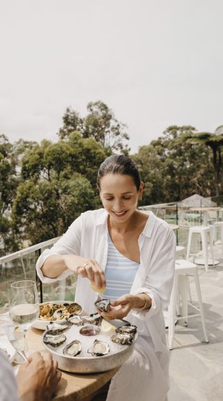 Woman enjoying fresh oysters at Bannisters, Port Stephens