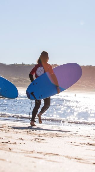 Couple learning to surf with Pines Surfing Academy Surf School at Killalea Beach ('The Farm'), Shell Cove, Shellharbour Area