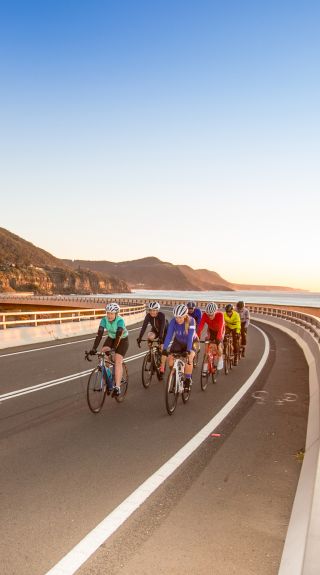 Biking in a group along Sea Cliff Bridge