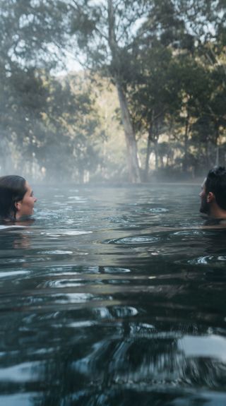 Couple enjoying a dip in the natural thermal springs in the Yarrangobilly area, Kosciuszko National Park