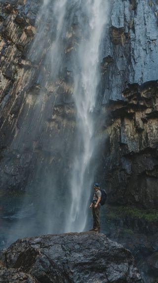 Person standing below the waterfall, Minyon Falls, Nightcap National Park - Credit: Lismore City Council