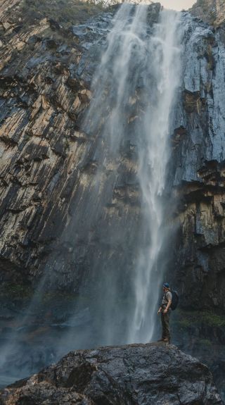 Person standing below the waterfall, Minyon Falls, Nightcap National Park - Credit: Lismore City Council