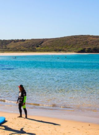Couple taking surf lessons at The Farm in Killalea State Park.