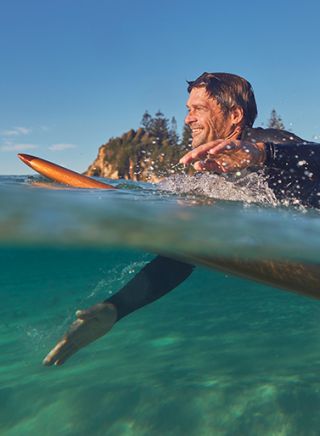 Man surfing at Glasshouse Rocks, Eurobodalla NSW