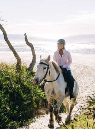 Woman enjoying a horse-riding experience with Zephryr Horses in Byron Bay