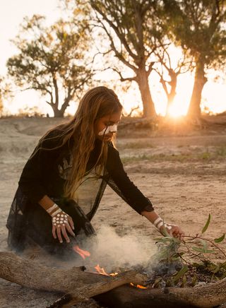 Young girl from the Barkindji nation preparing leaves for a smoking ceremony in Wilcannia.