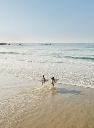 Couple enjoying a morning surf at Birubi Beach, Port Stephens
