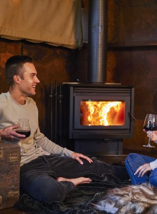 Couple enjoying a romantic night by the fireplace at Spicers Sangoma Retreat, Bowen Mountain
