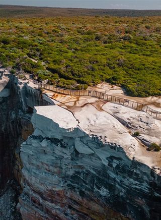 Aerial photo of Wedding Cake Rock with a large safety fence around a section of land to prevent visitors being in Royal National Park 