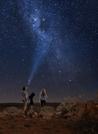 Couple star gazing beneath the Milky Way at Outback Astronomy
